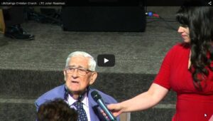 Elderly man interviewed at church event stage