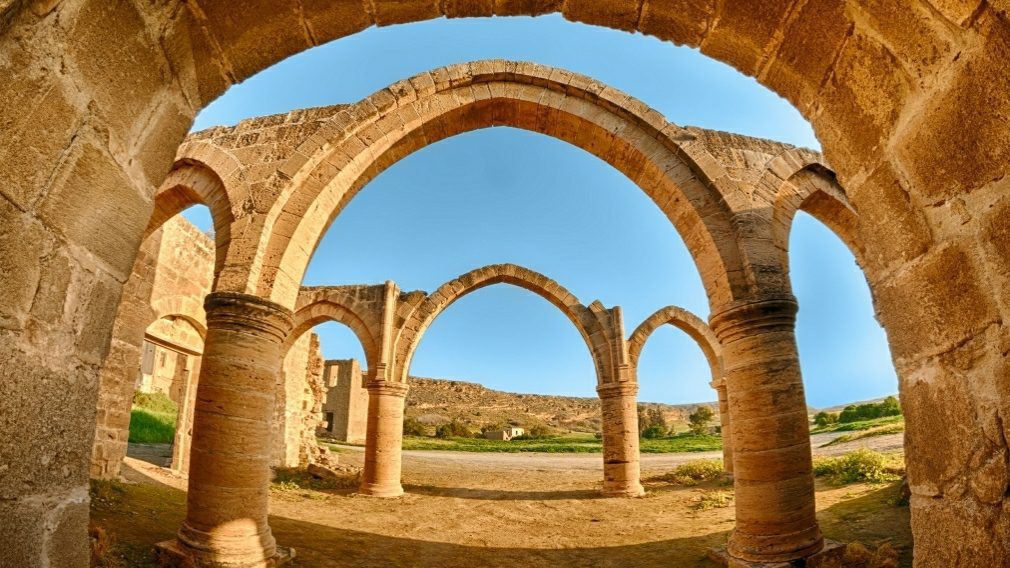 Ancient stone arches under a clear sky.