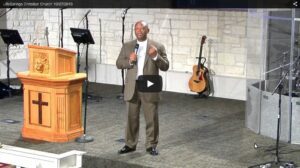 Man speaking at church with musical instruments