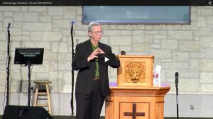 Man delivering a sermon at a church podium.