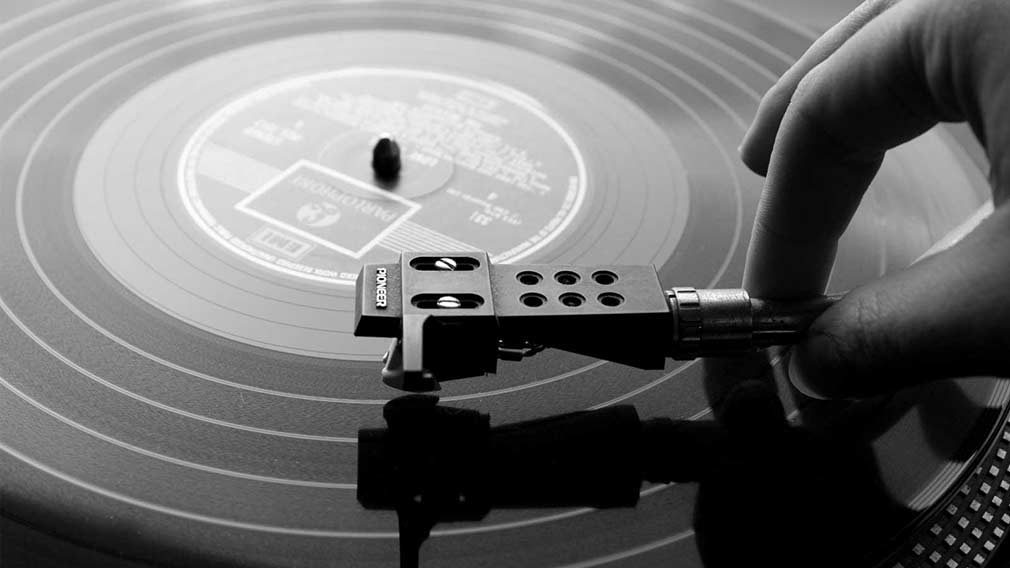 Hand placing stylus on a vinyl record