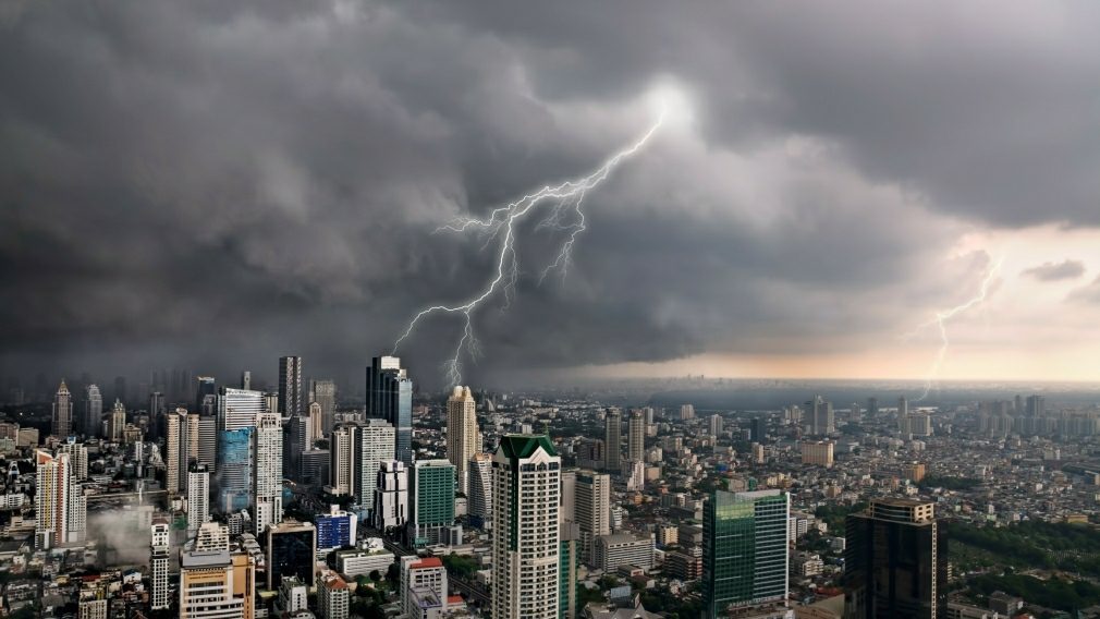 Lightning storm over city skyline with skyscrapers.