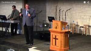 Preacher delivering sermon on stage in church