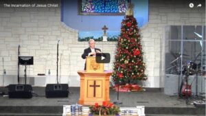 Christmas service with preacher and decorated tree