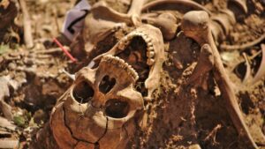 Ancient human skeleton partially buried in dirt