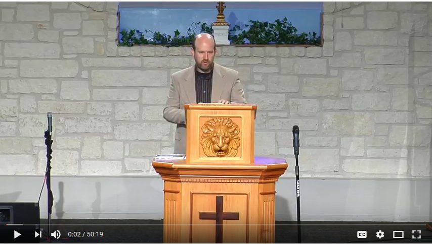 Man speaking at church podium during sermon.