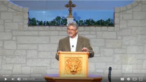 Man giving a sermon at church podium.