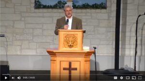 Speaker at church podium delivering a sermon