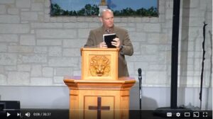 Man speaking at a church podium during sermon