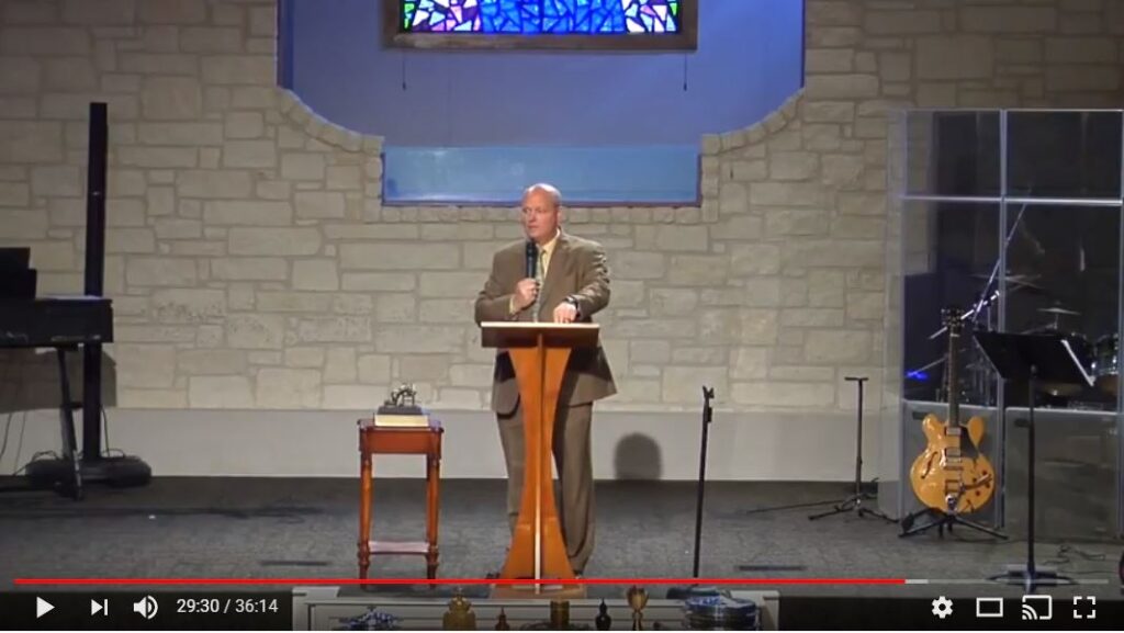 Pastor giving sermon at church podium altar