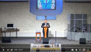 Pastor delivering sermon at church podium stage