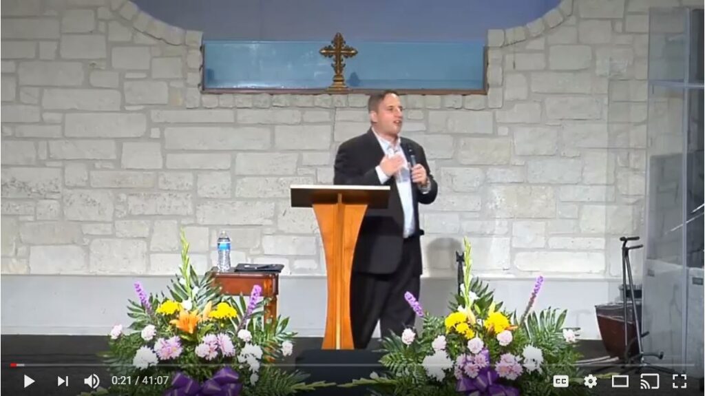 Speaker delivering sermon at church podium indoors