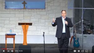 Man speaking at church podium during service