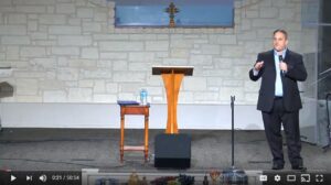 Man speaking on stage in a church setting