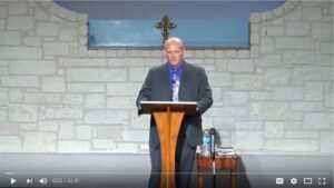 Person delivering a speech at a podium.