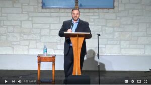 Man speaking at podium in church setting