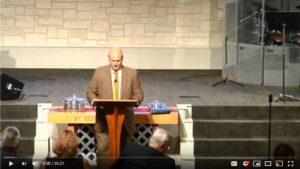 Man giving a sermon at a church podium