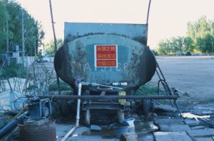 Rusty industrial water tank with pipes outdoors