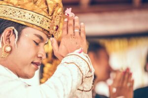 Man in traditional attire performing a prayer ceremony