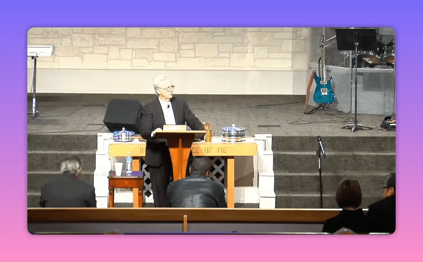 centered shot of speaker at pulpit with communion trays and stage background
