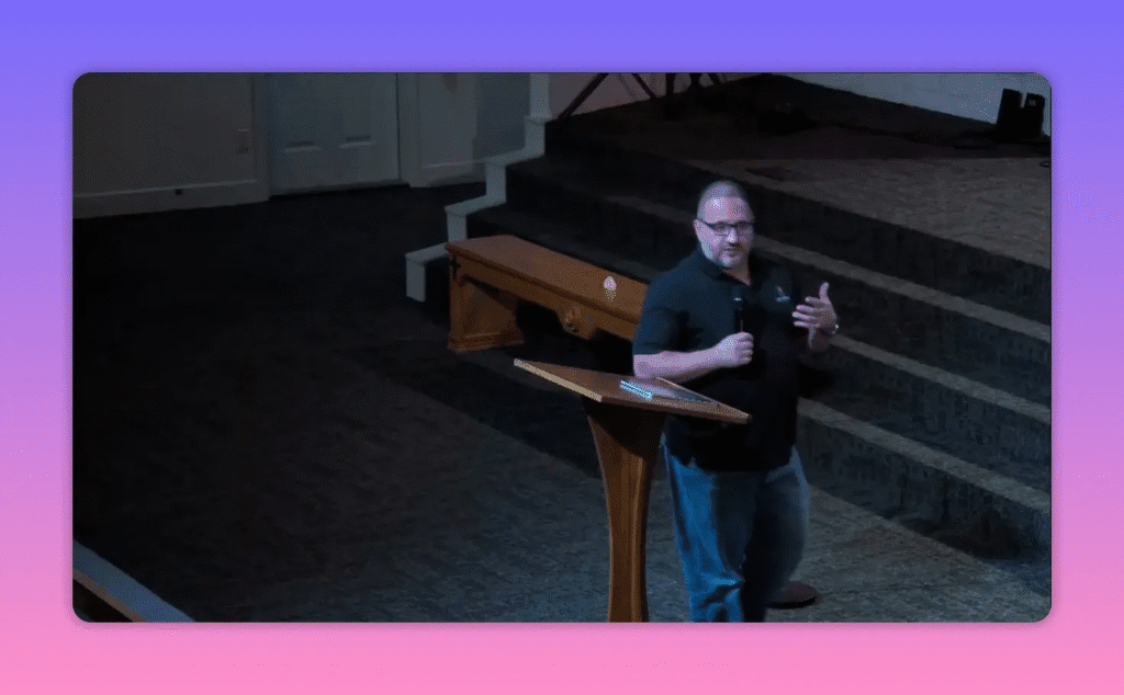 Pastor gesturing while speaking at a lectern on a church platform