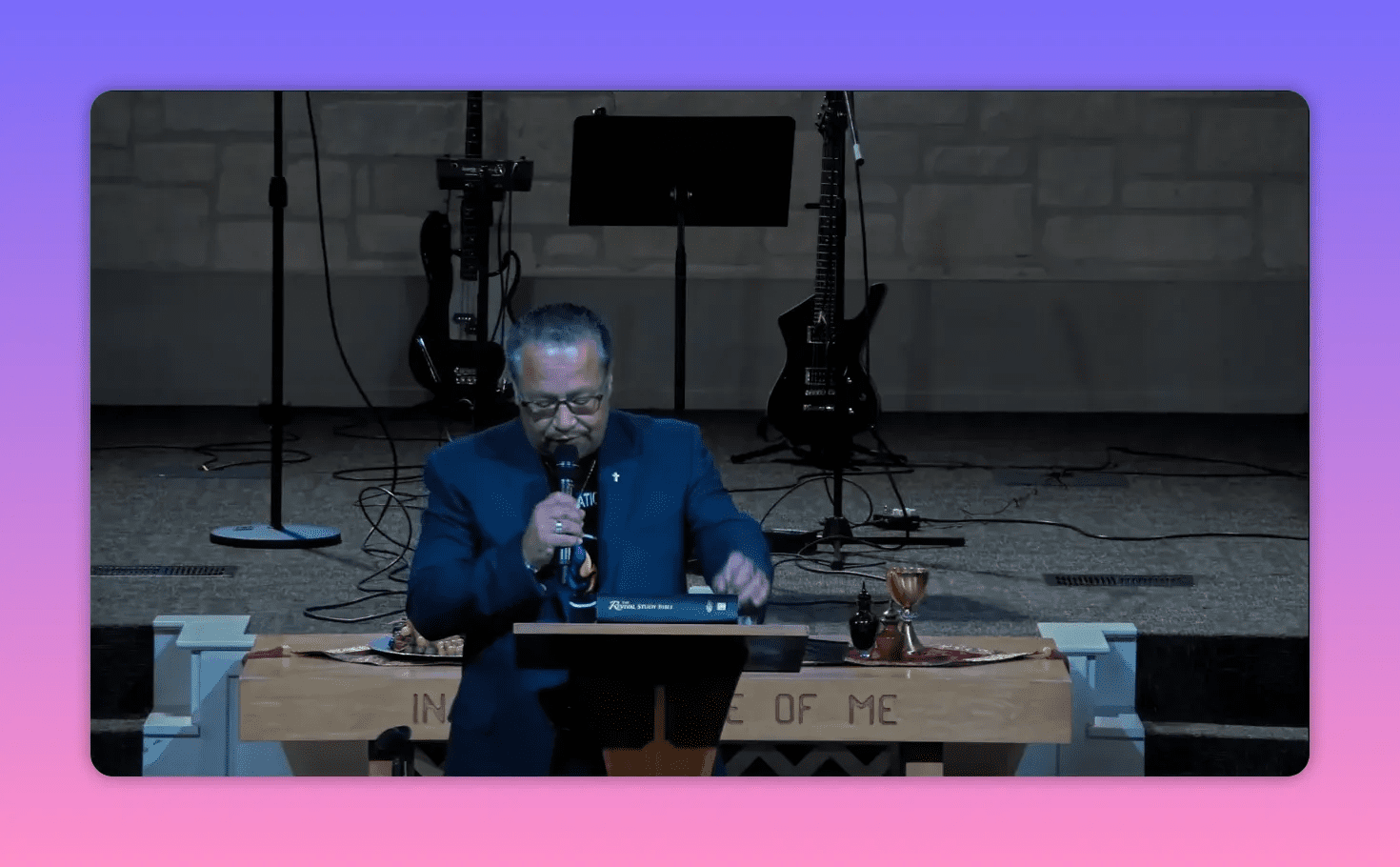 Pastor reading and speaking at a pulpit with Bible and communion items visible