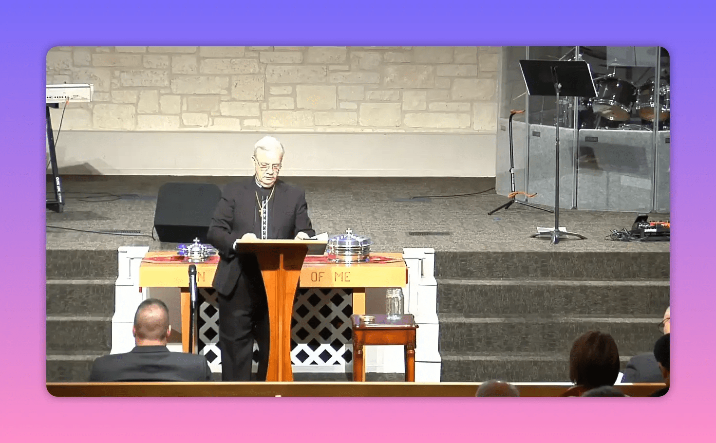 speaker at pulpit reading from an open Bible