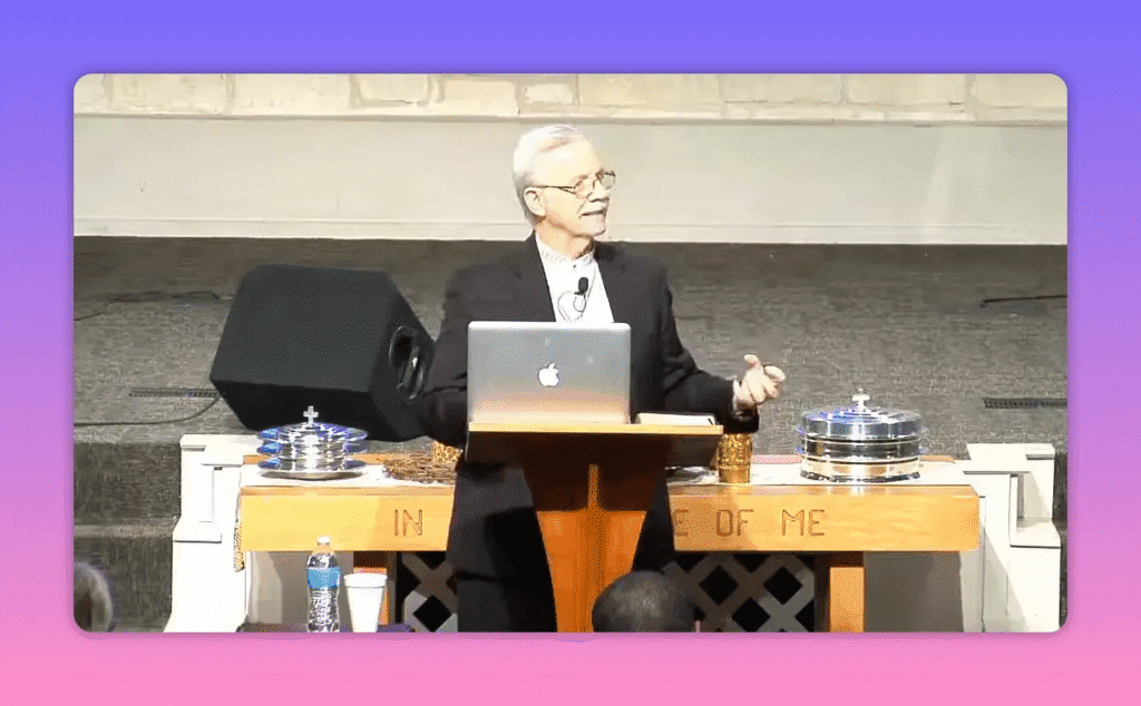 speaker using open hand gestures at pulpit with communion table foreground