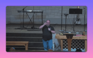 Speaker gesturing while delivering a sermon at a church pulpit with communion elements visible