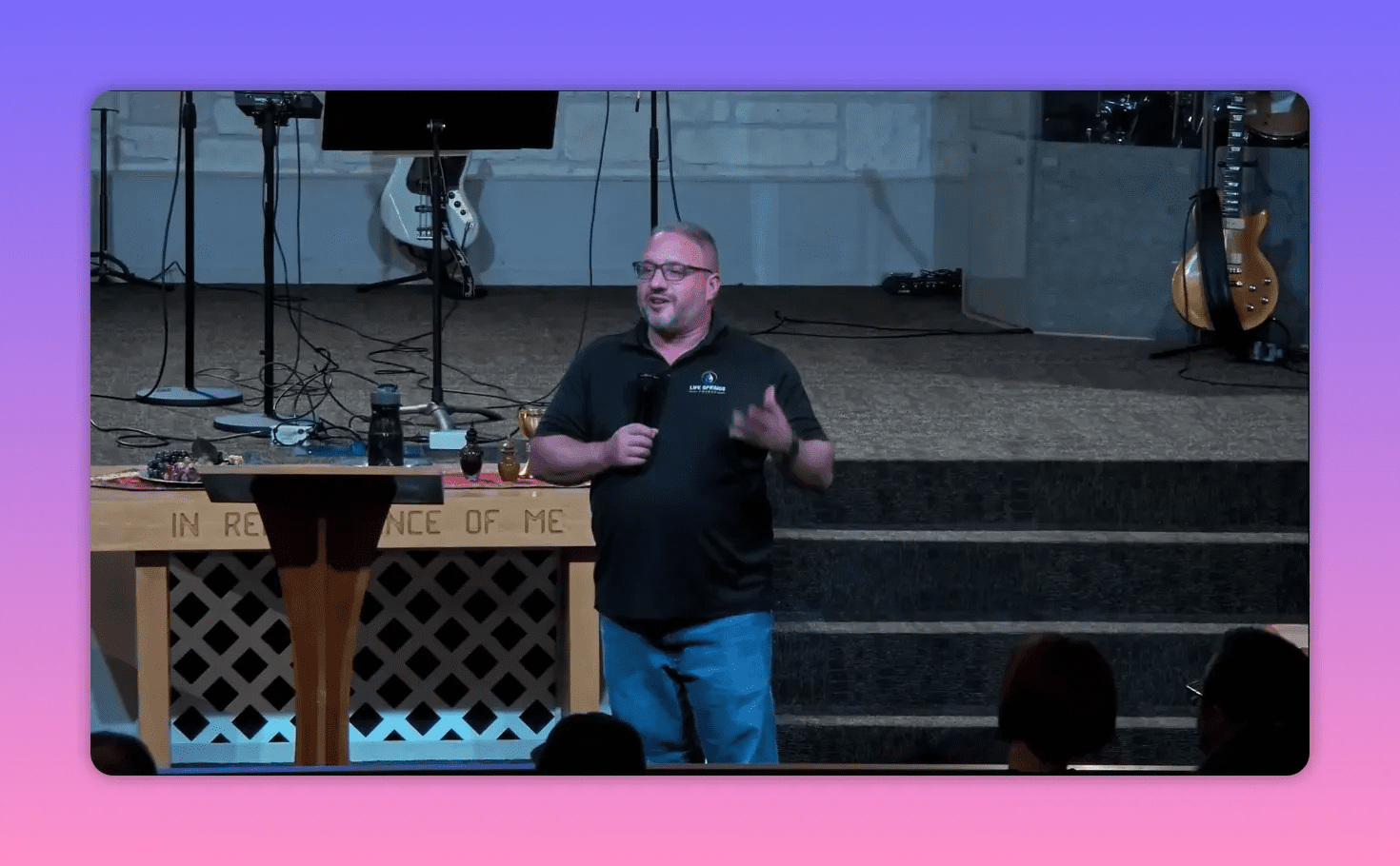 Speaker with open hand making a teaching point in front of the communion table