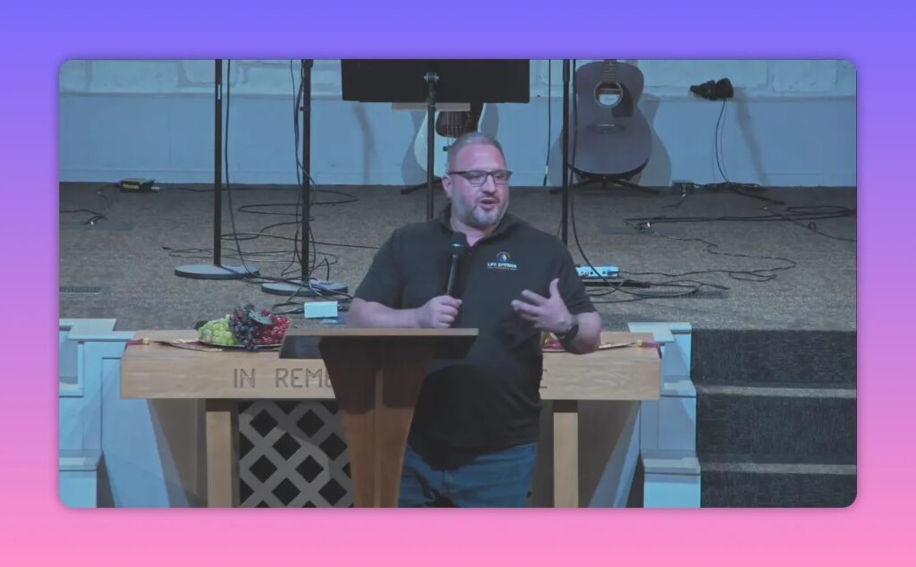 Speaker at pulpit, hand on chest while addressing the congregation, clear medium shot