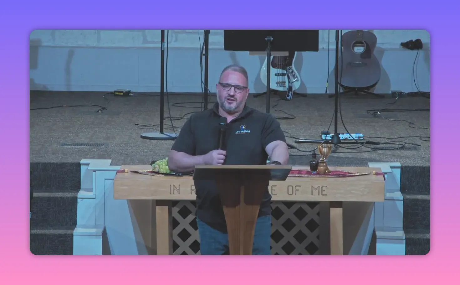 Wide shot of pastor at pulpit with grapes and chalice on the communion table