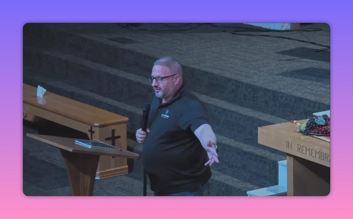 speaker at pulpit extending arm in expressive gesture, wide view showing lectern and altar