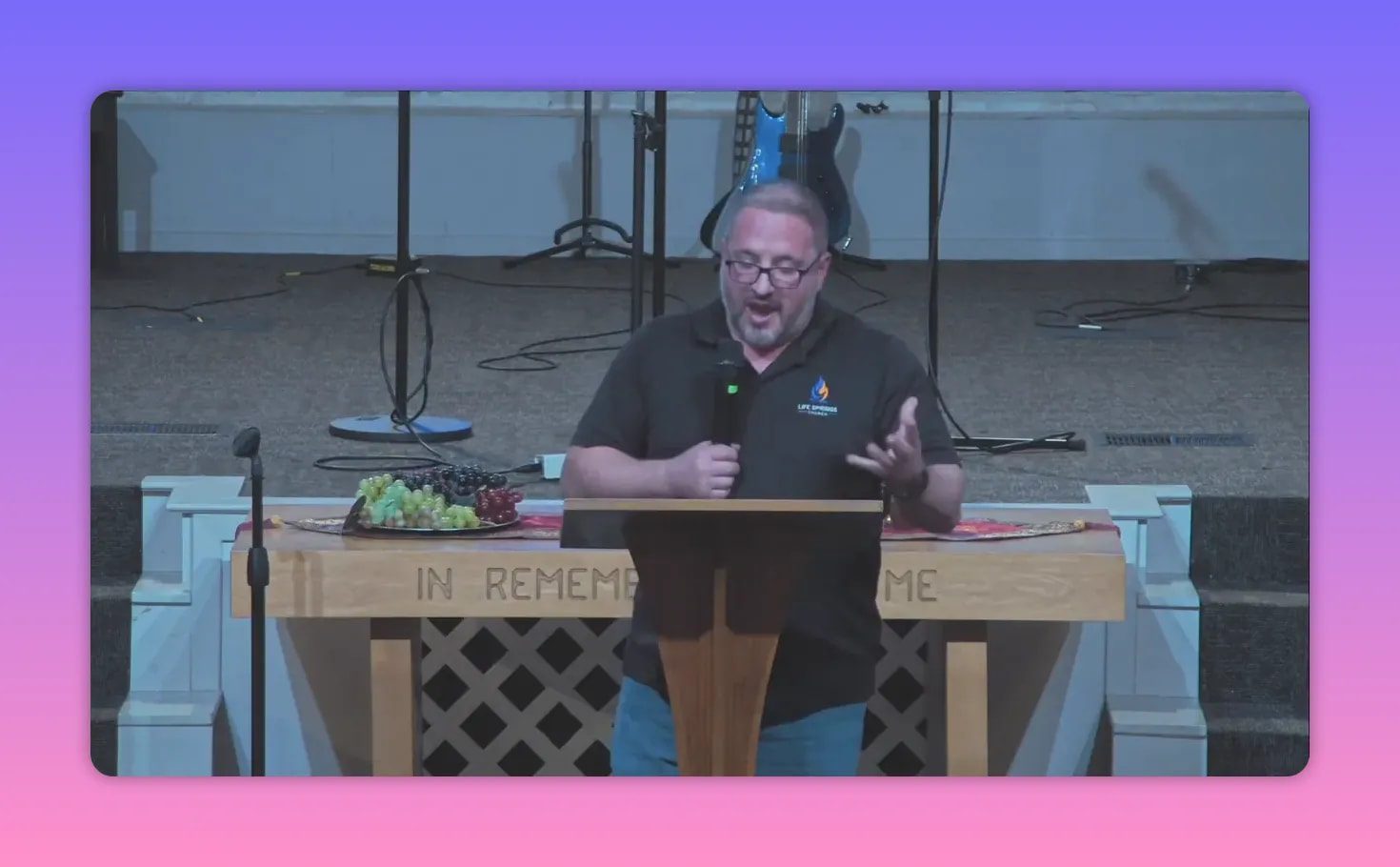 Pastor mid-speech at a pulpit with a communion table (inscribed 