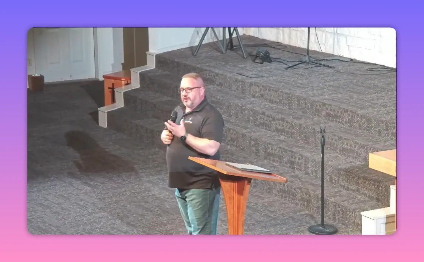 Pastor speaking at a wooden lectern on a raised church platform with steps and microphone stand visible