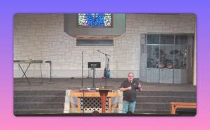 Church speaker gesturing while teaching at lectern in church sanctuary