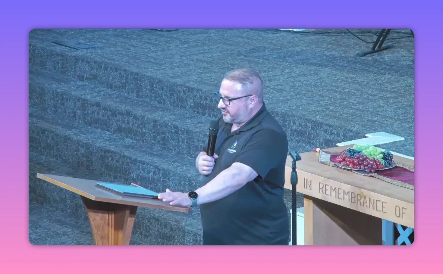Church speaker holding a microphone at the lectern with rainy backdrop