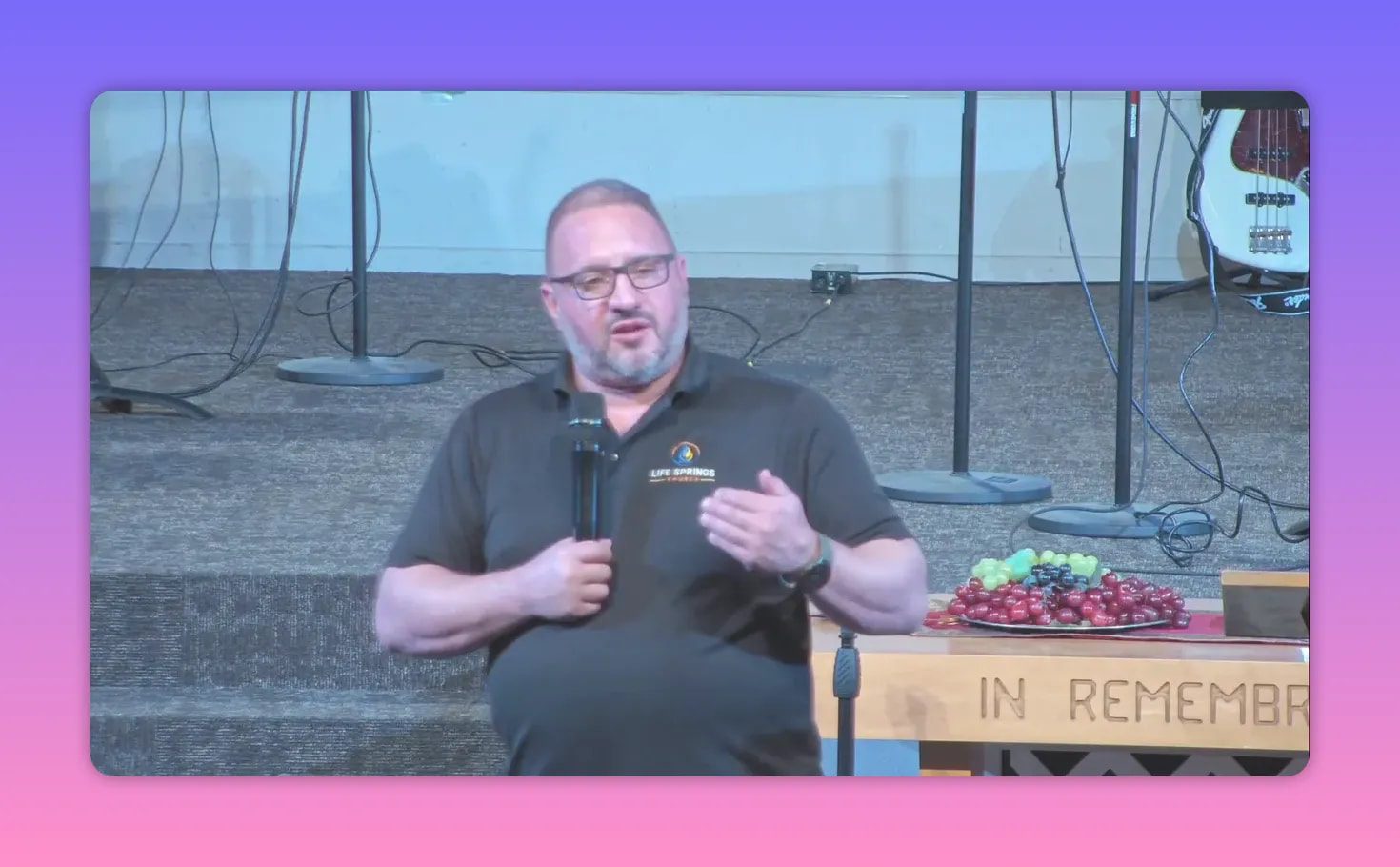 Church speaker holding microphone and gesturing during teaching on hope and endurance in Christ