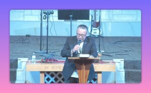Preacher delivering a sermon at a church podium with microphone and open notes