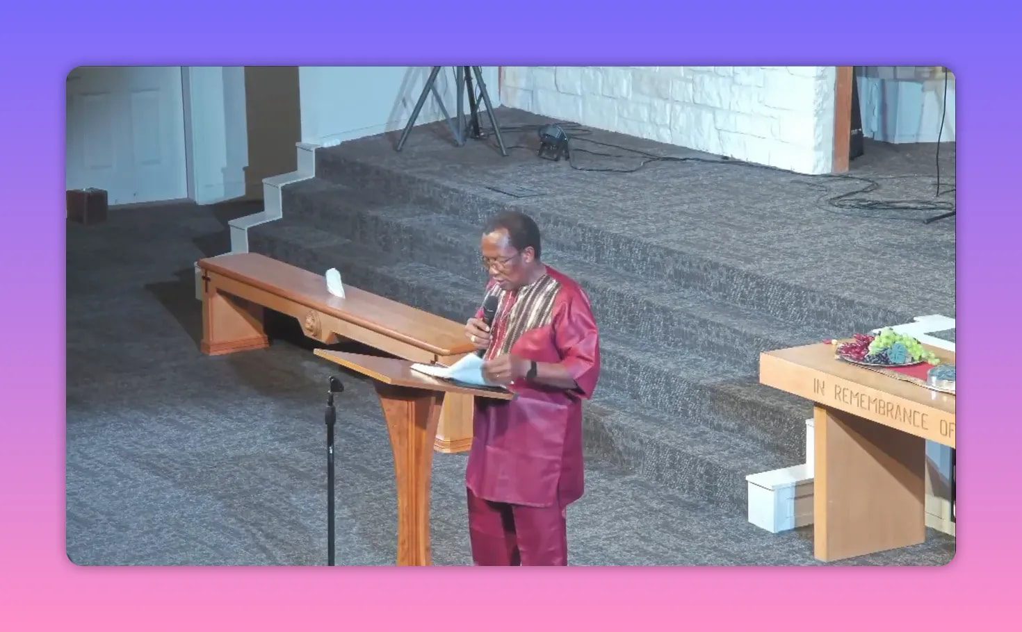 Pastor speaking at a lectern with microphone in a church sanctuary