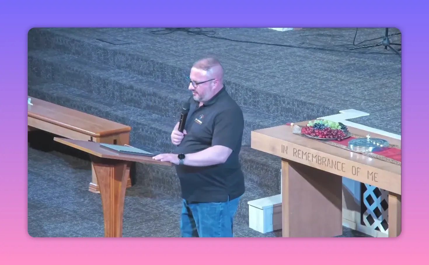 Pastor speaking near the communion table with the lectern in view