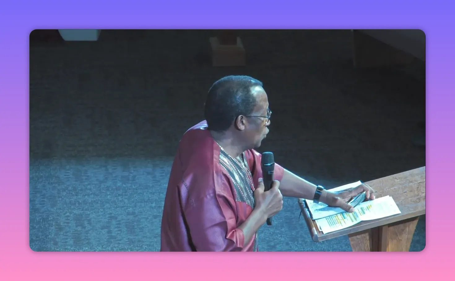 Pastor speaking beside a lectern and open Bible during a sermon about freedom from a yoke