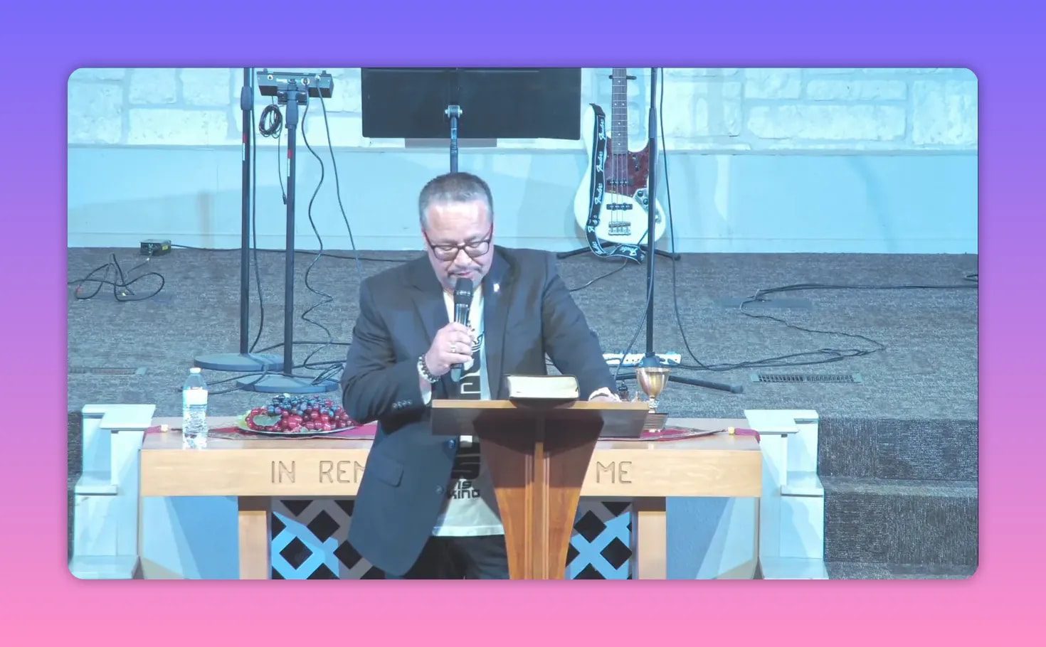 Pastor speaking at a church lectern with microphone, addressing the congregation